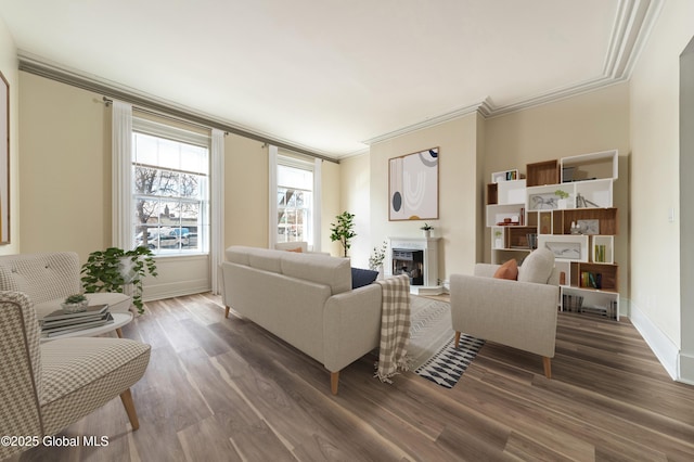 living area featuring ornamental molding, a fireplace, dark wood finished floors, and baseboards