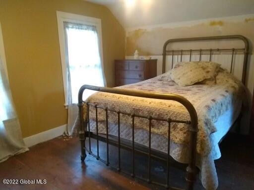 bedroom featuring hardwood / wood-style floors and vaulted ceiling