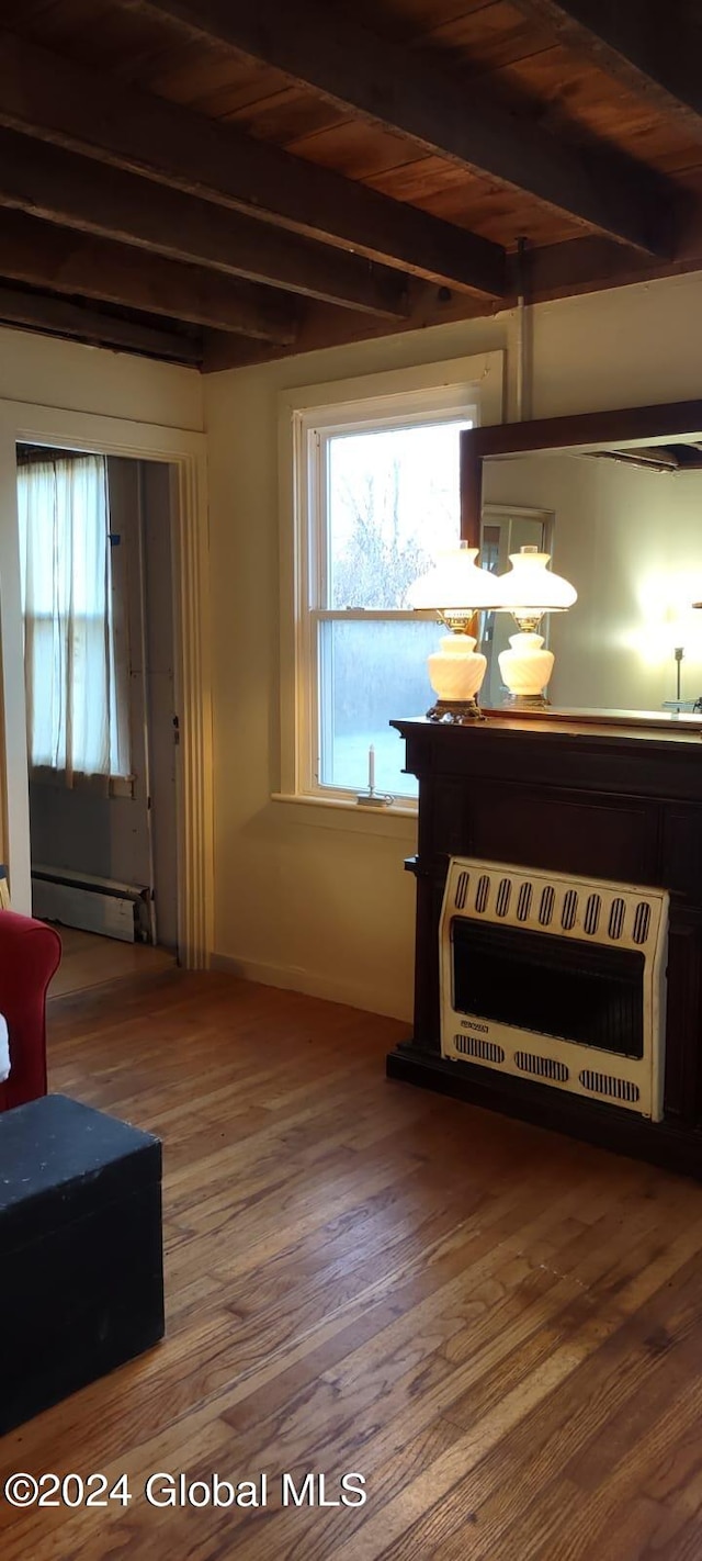 living room with beamed ceiling, wood-type flooring, heating unit, and a baseboard heating unit