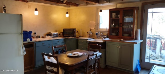 kitchen with a wealth of natural light, sink, decorative light fixtures, and white refrigerator