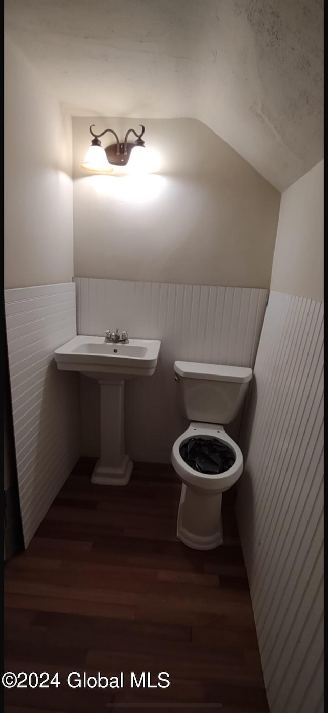 bathroom featuring toilet, wood-type flooring, and vaulted ceiling