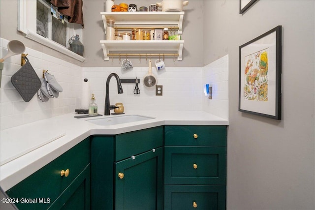 bar with backsplash, sink, and green cabinetry