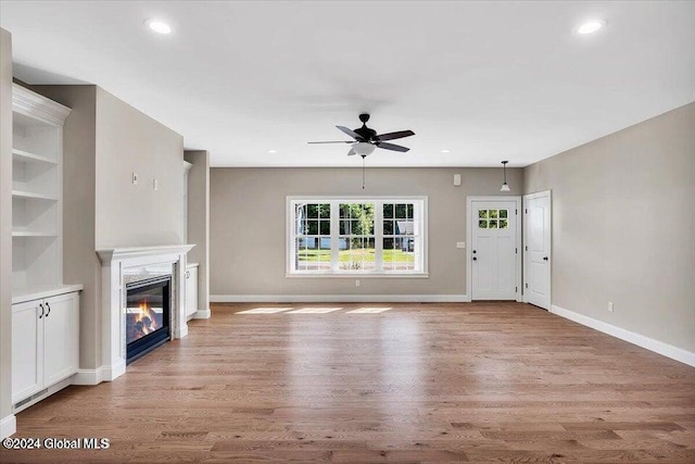 unfurnished living room featuring ceiling fan and light wood-type flooring