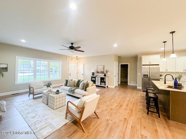 living room with ceiling fan and light hardwood / wood-style floors