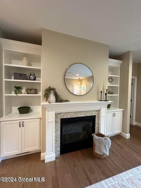 unfurnished living room featuring dark wood-type flooring and a premium fireplace