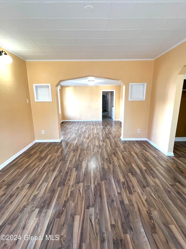 spare room featuring dark hardwood / wood-style floors and ornamental molding