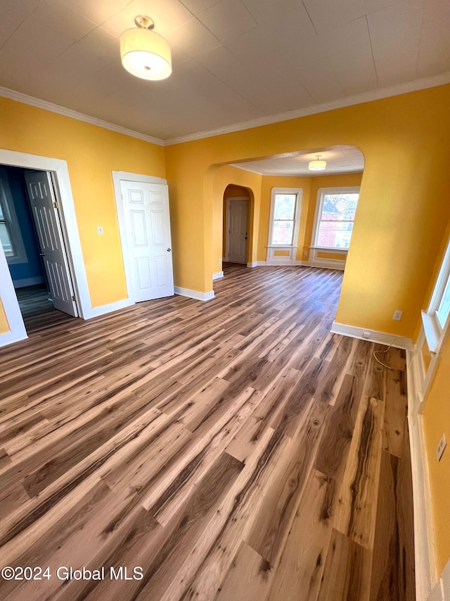 empty room with crown molding and hardwood / wood-style flooring