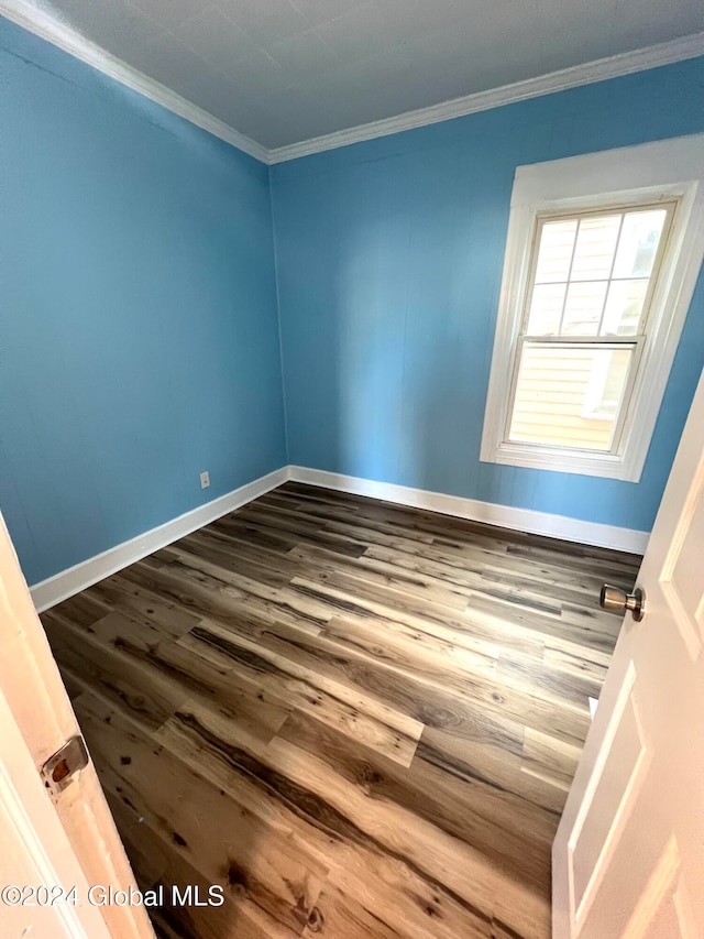 spare room with hardwood / wood-style flooring and crown molding