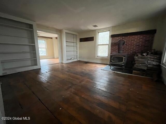 unfurnished living room with hardwood / wood-style flooring and a wood stove