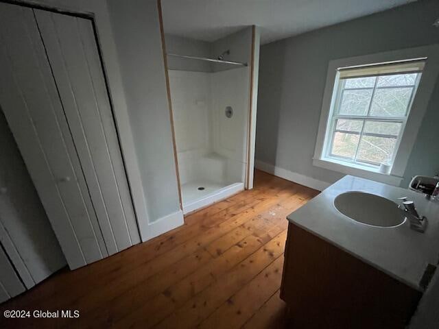 bathroom with a shower, vanity, and wood-type flooring