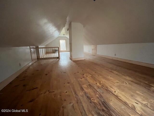 bonus room with lofted ceiling and wood-type flooring