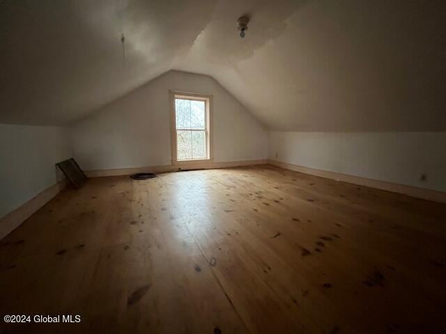 bonus room with light hardwood / wood-style flooring and lofted ceiling