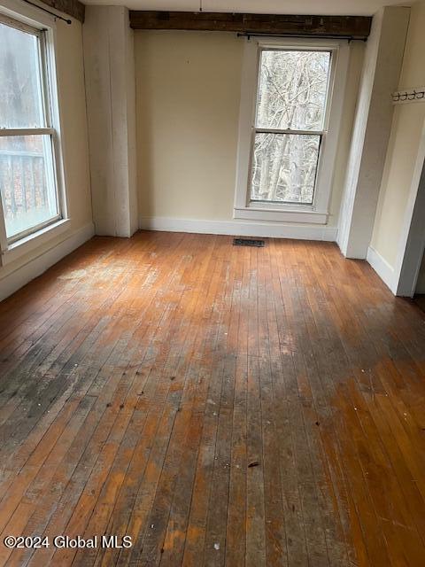 unfurnished room with hardwood / wood-style floors and a healthy amount of sunlight