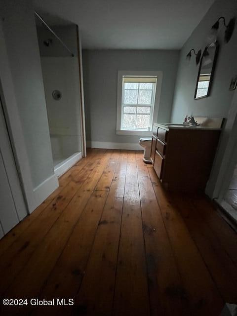 bathroom with hardwood / wood-style floors, vanity, and a shower