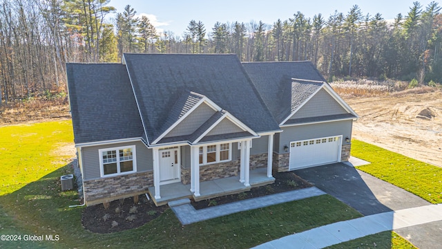 view of front of property with central AC, a front lawn, and a garage