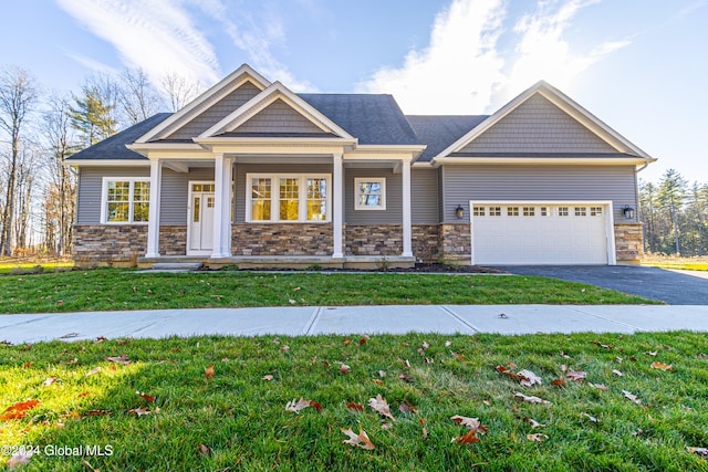 craftsman house featuring a front yard and a garage