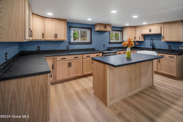 kitchen featuring a center island, light wood-type flooring, sink, and light brown cabinetry