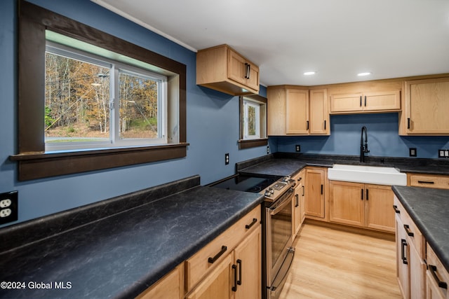 kitchen featuring light brown cabinetry, sink, light hardwood / wood-style floors, and stainless steel range with electric stovetop