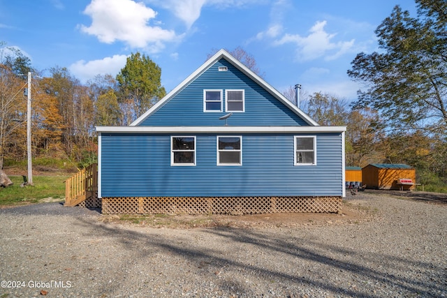 view of side of home featuring a storage shed