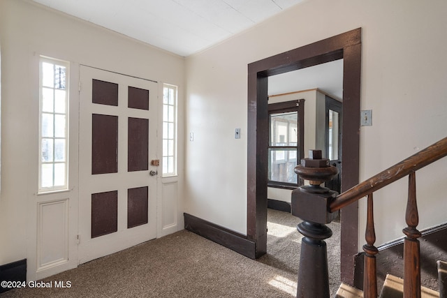 foyer entrance with carpet flooring