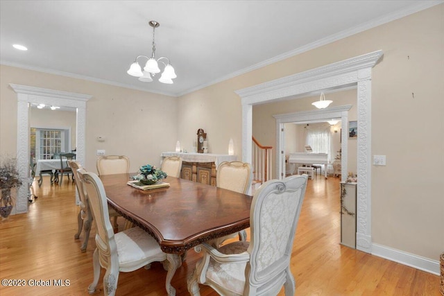 dining area with an inviting chandelier, light hardwood / wood-style flooring, and crown molding