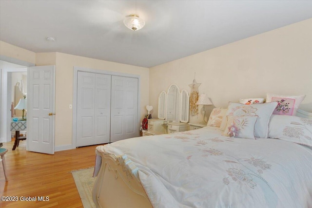 bedroom with light hardwood / wood-style floors and a closet