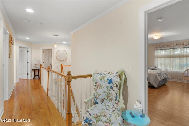 hall with light hardwood / wood-style floors and ornamental molding