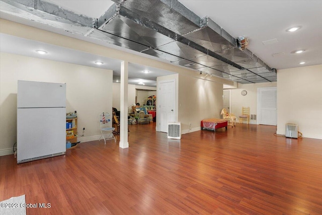 basement featuring hardwood / wood-style floors and white fridge