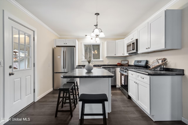 kitchen featuring ornamental molding, stainless steel appliances, pendant lighting, white cabinets, and dark hardwood / wood-style floors