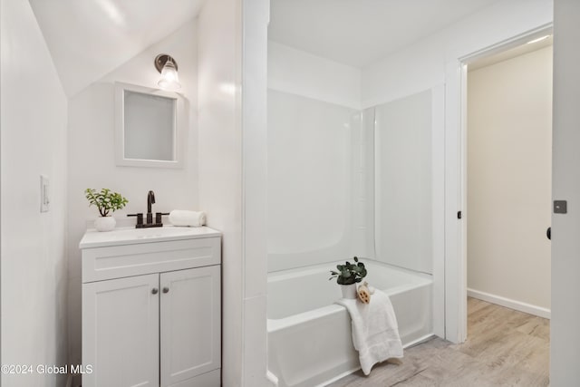 bathroom with hardwood / wood-style flooring, vanity, and shower / tub combination