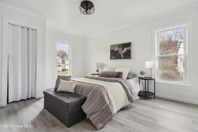 bedroom featuring crown molding and light wood-type flooring