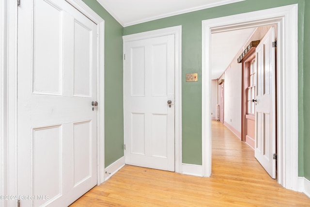 hall featuring ornamental molding and light hardwood / wood-style floors