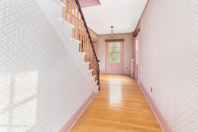 hall with radiator heating unit and light hardwood / wood-style flooring