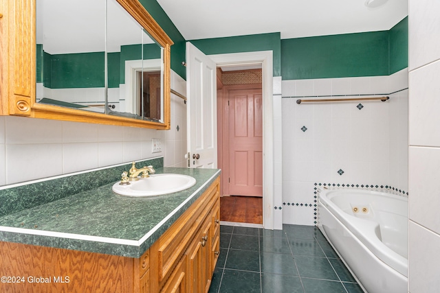 bathroom featuring tile walls, vanity, a bathtub, and tile patterned floors