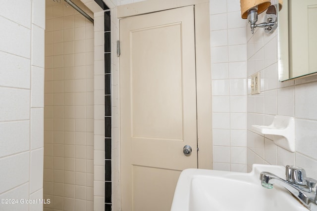 bathroom featuring tile walls and sink