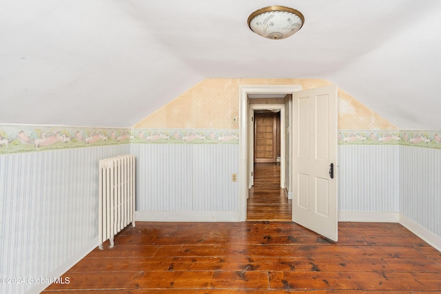 bonus room featuring radiator heating unit, dark hardwood / wood-style floors, and vaulted ceiling