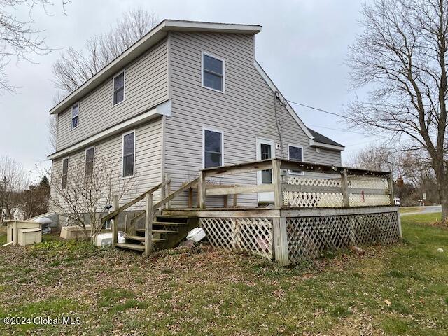 rear view of property with a yard and a deck