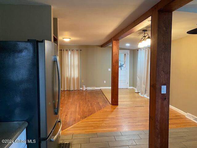 kitchen featuring hanging light fixtures, stainless steel refrigerator, and light hardwood / wood-style flooring