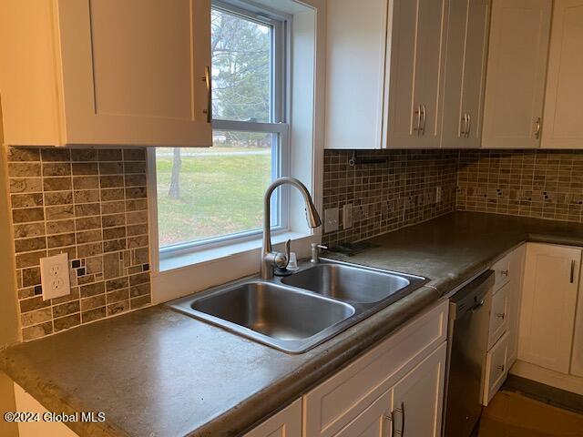 kitchen with dishwasher, sink, and tasteful backsplash