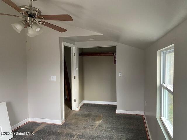 unfurnished bedroom with multiple windows, a closet, ceiling fan, and lofted ceiling