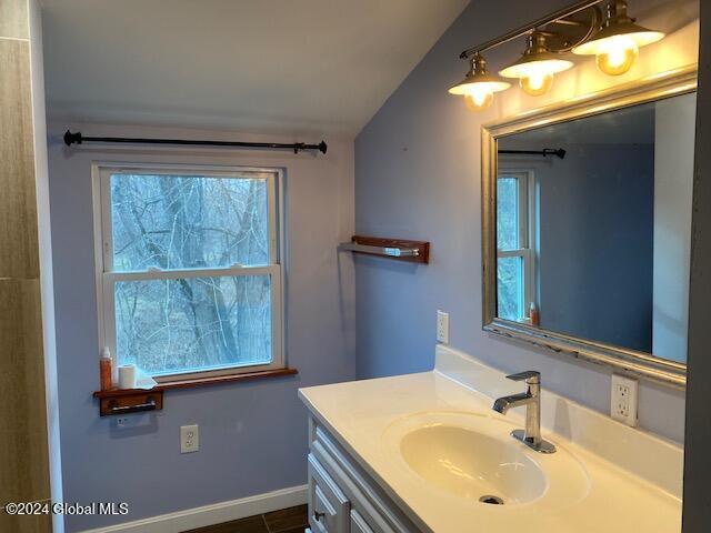 bathroom featuring vanity and lofted ceiling