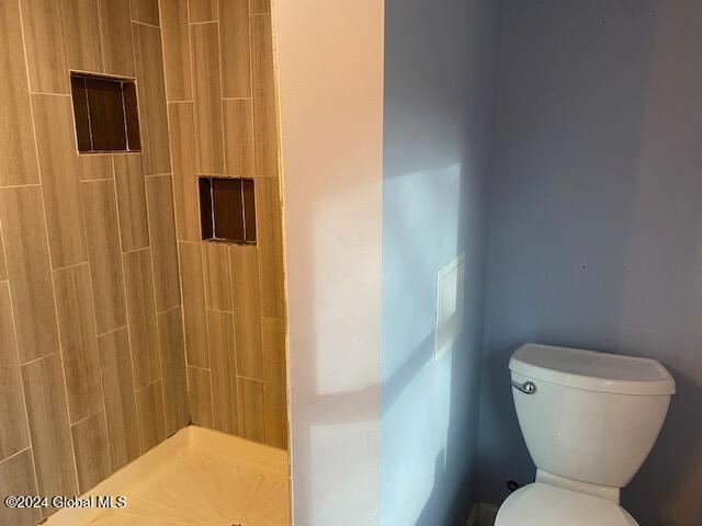 bathroom featuring a shower and toilet