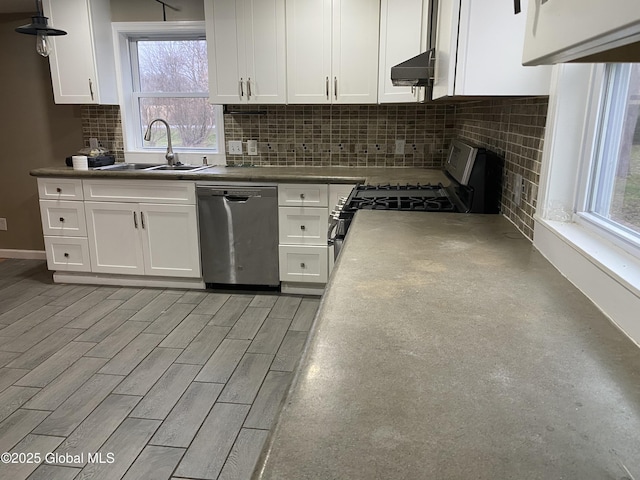 kitchen featuring appliances with stainless steel finishes, white cabinetry, range hood, and sink