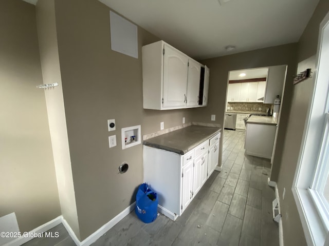 kitchen with backsplash, white cabinets, and stainless steel dishwasher