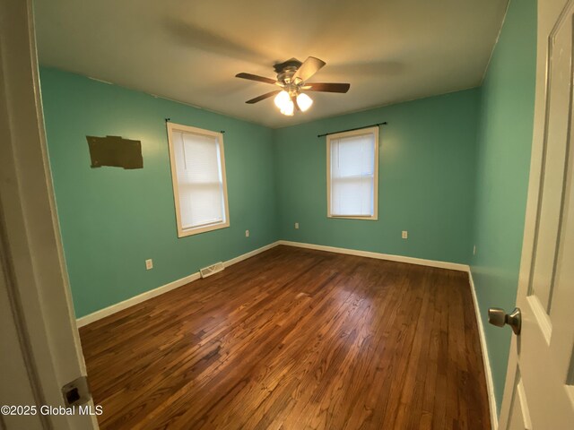 spare room with ceiling fan and dark hardwood / wood-style floors