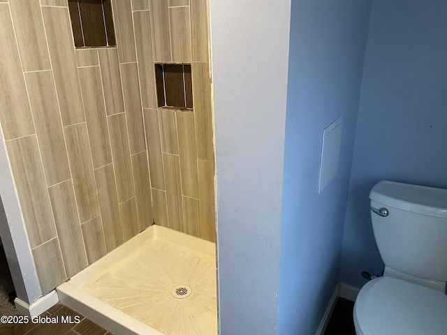 bathroom featuring a shower and toilet