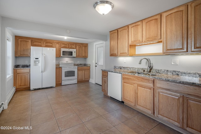 kitchen featuring stone counters, light tile patterned floors, white appliances, and sink