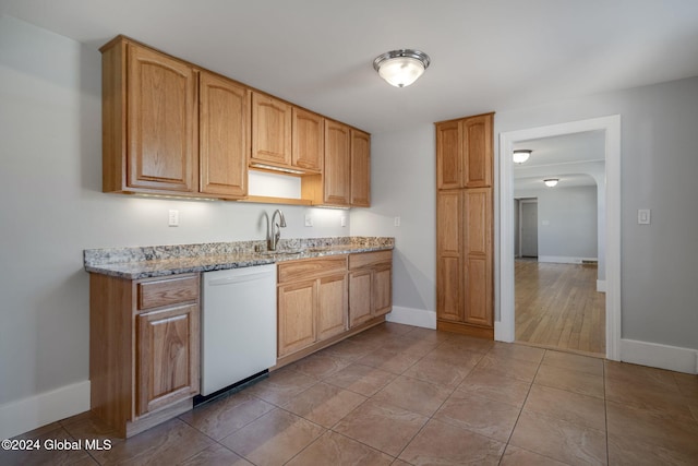 kitchen featuring light stone countertops, white dishwasher, light hardwood / wood-style flooring, and sink