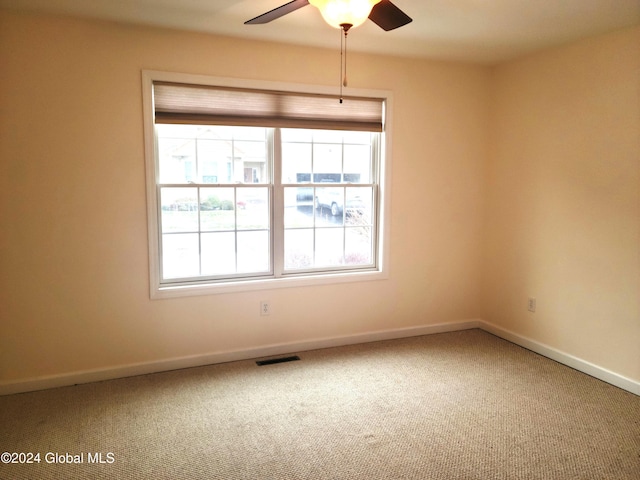 carpeted spare room featuring ceiling fan