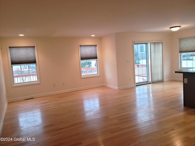 unfurnished room with plenty of natural light and light hardwood / wood-style flooring